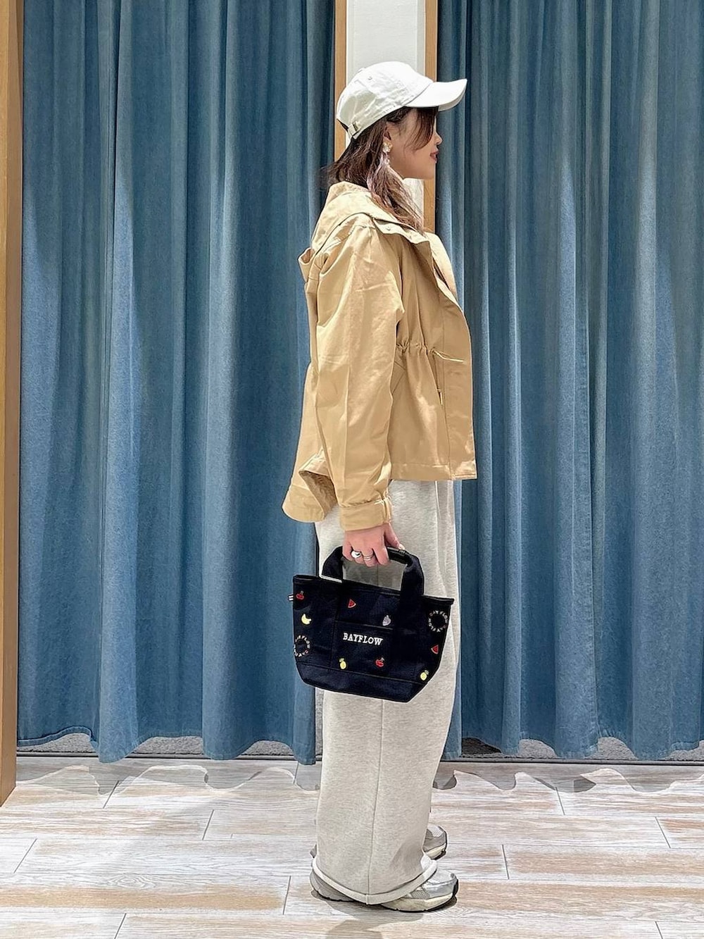 ブラック系のTシャツ/カットソー、イエロー系のマウンテンパーカー、ホワイト系のスウェットパンツを着用したレディースの春コーディネートの2枚目の写真