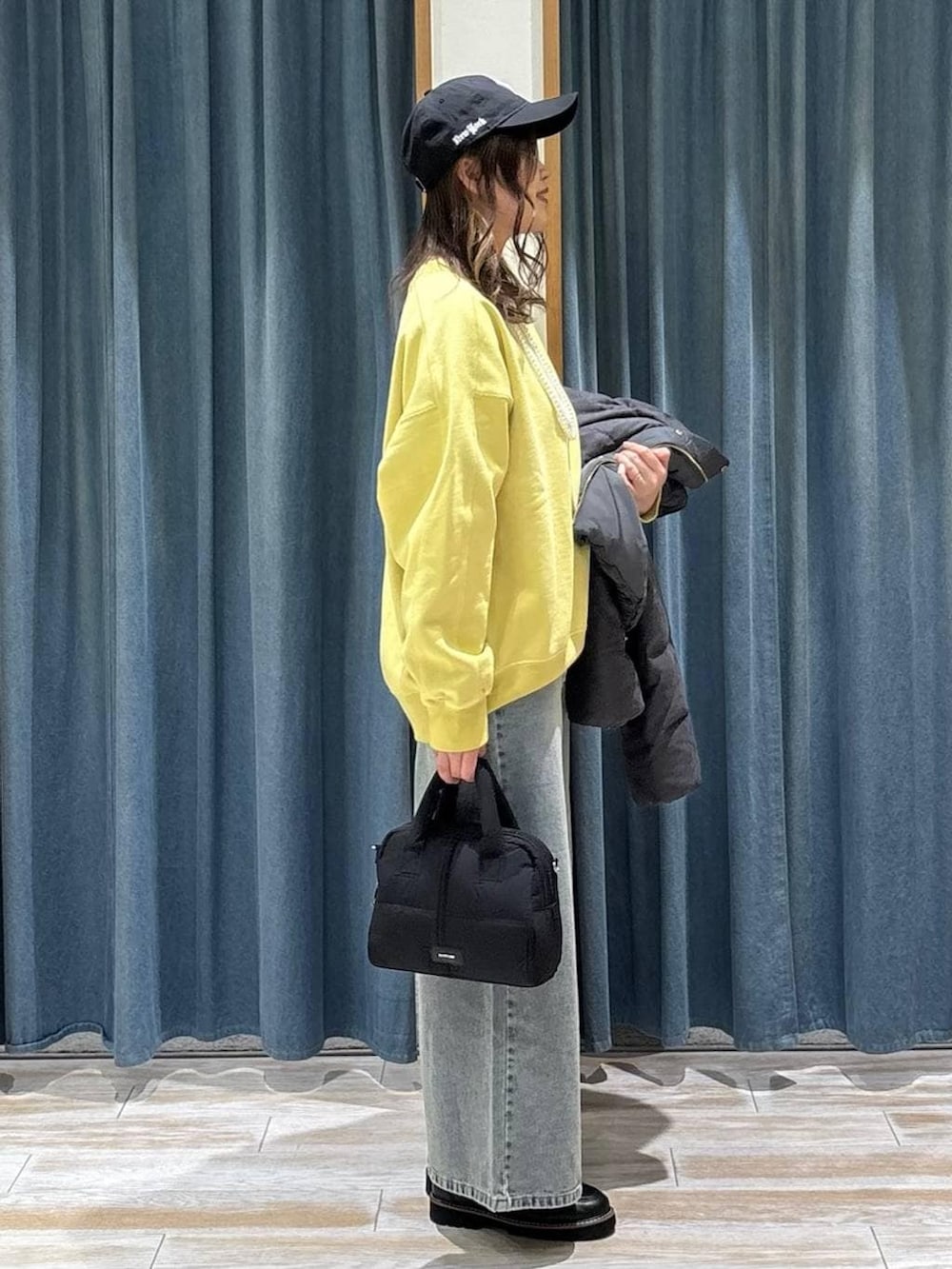 グレー系のダウンジャケット/コート、ブラック系のローファー、ブラック系のボストンバッグを着用したレディースの冬コーディネートの2枚目の写真