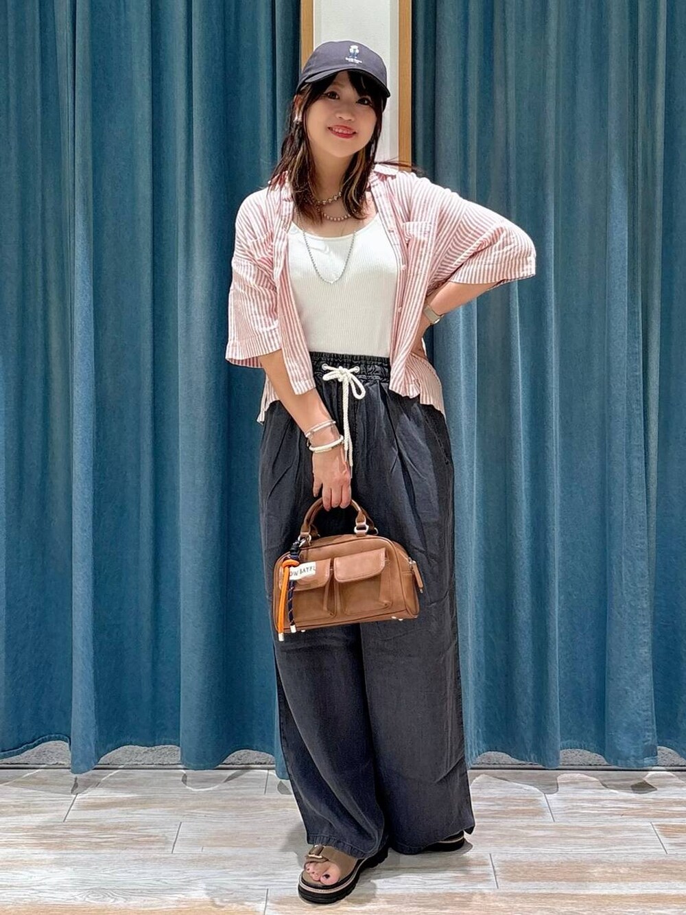 ホワイト系のキャミソール、ベージュ系のサンダル、ブラック系のその他パンツを着用したレディースの夏コーディネートの4枚目の写真