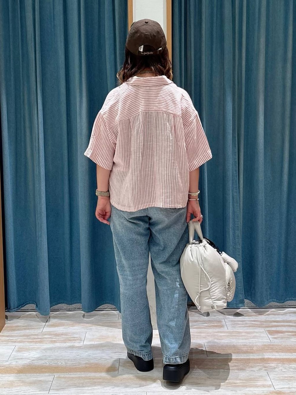 ブラック系のキャミソール、ブルー系のデニムパンツ、ブラック系のサンダルを着用したレディースの夏コーディネートの3枚目の写真