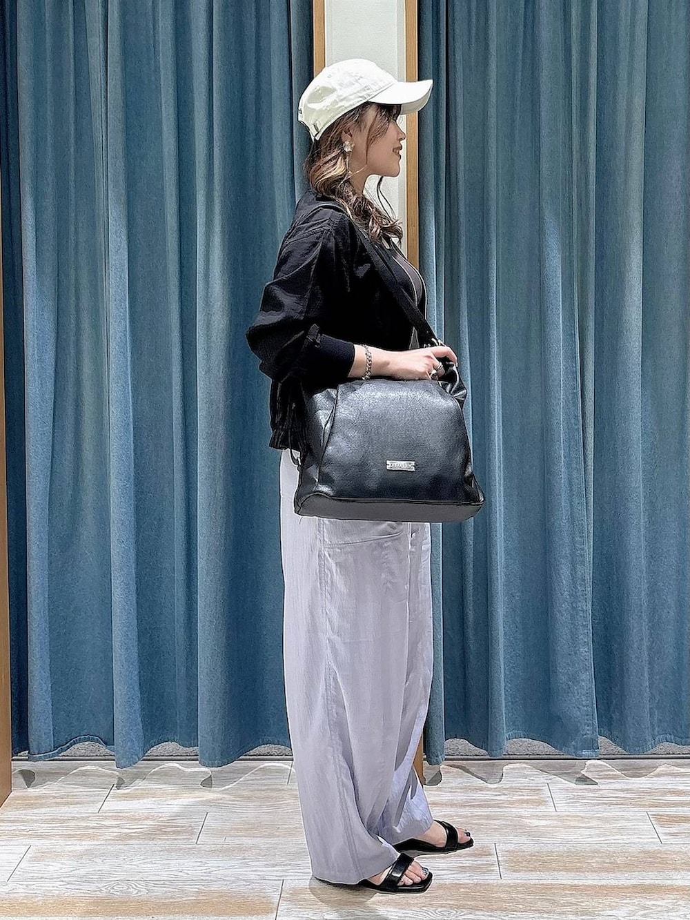 ブラック系のブルゾン、パープル系のその他パンツ、ブラック系のトートバッグを着用したレディースの春コーディネートの2枚目の写真