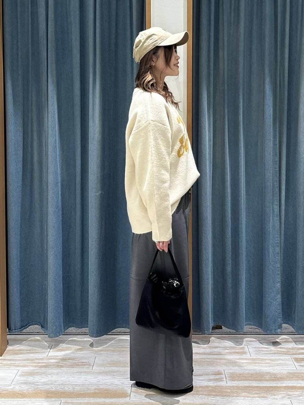 グレー系のその他パンツ、ブラック系のローファー、ホワイト系のニット/セーターを着用したレディースの秋コーディネートの2枚目の写真