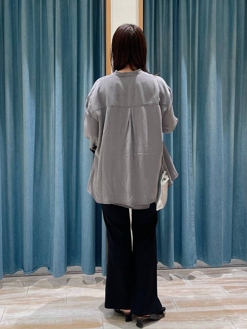 シルバー系のショルダーバッグ、グレー系のチュニック、ブラック系のパンプスを着用したレディースの冬コーディネートの3枚目の写真