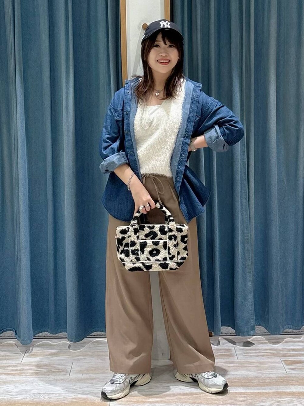 ブルー系のシャツ/ブラウス、ホワイト系のベスト、ベージュ系のトートバッグを着用したレディースの秋コーディネートの4枚目の写真