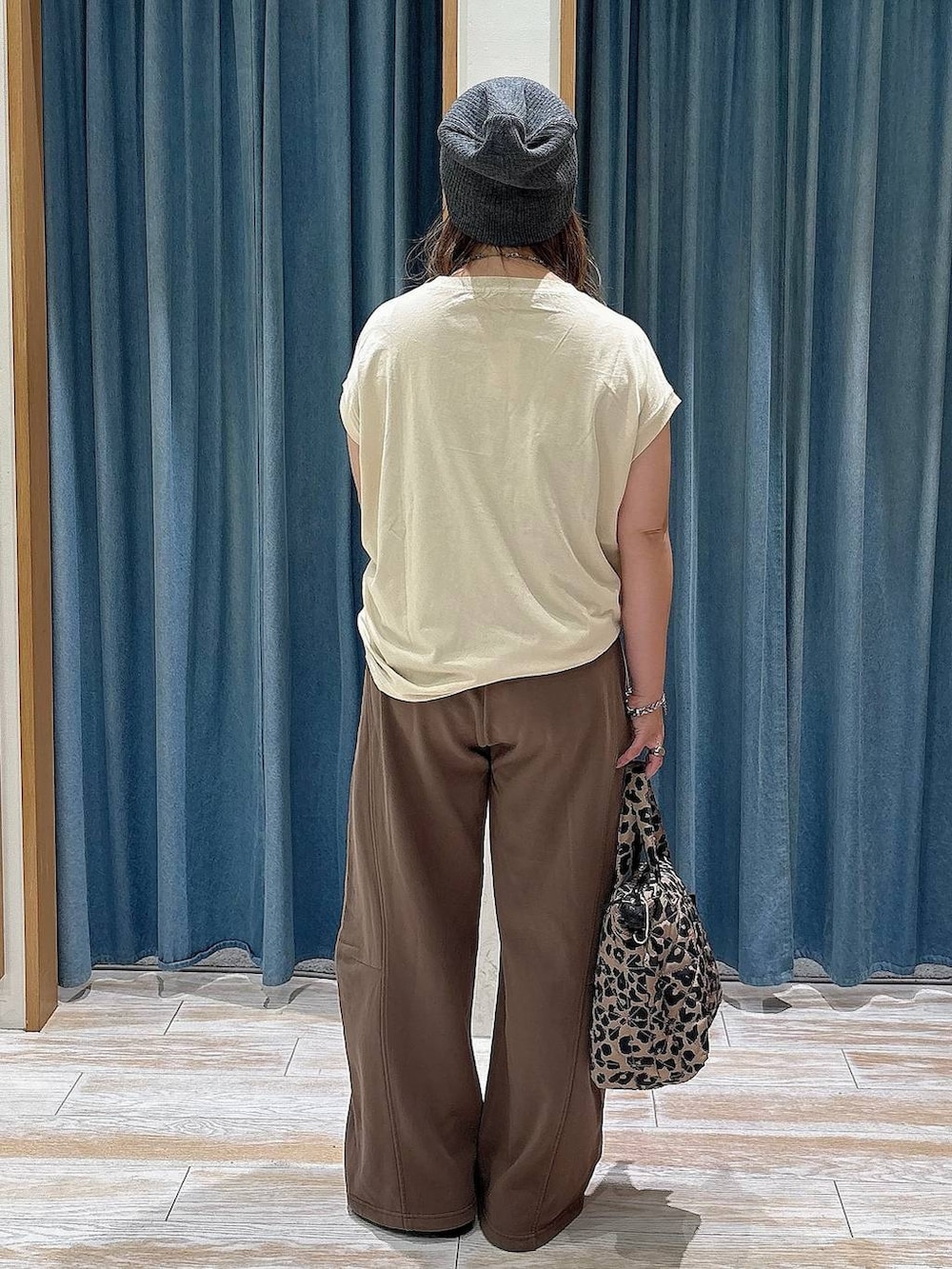 ベージュ系のTシャツ/カットソー、ブラック系のローファー、その他のトートバッグを着用したレディースの夏コーディネートの3枚目の写真