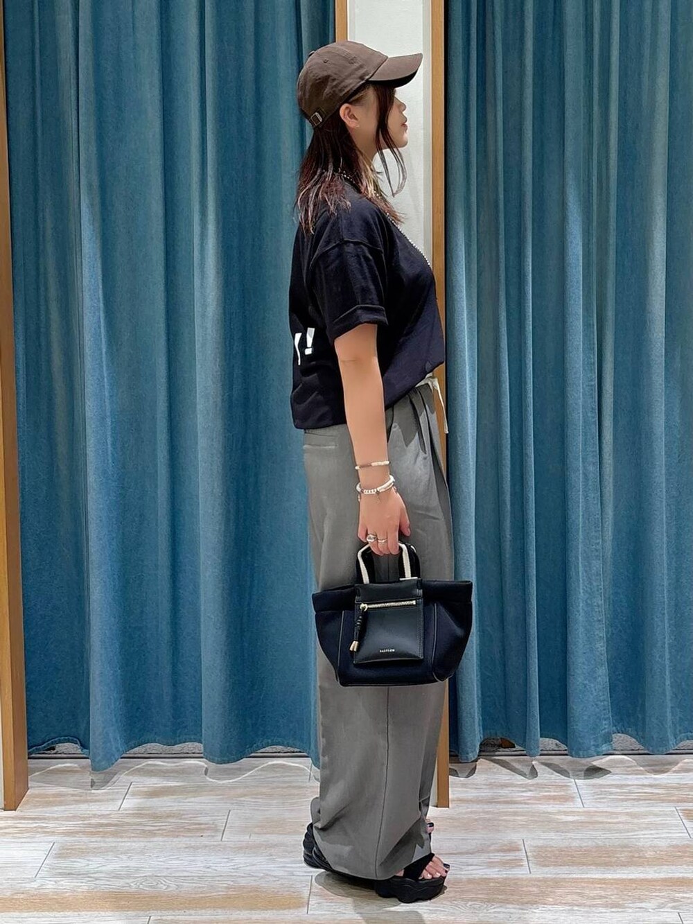 ブラック系のTシャツ/カットソー、ブラック系のショルダーバッグ、グレー系のその他パンツを着用したレディースの夏コーディネートの3枚目の写真