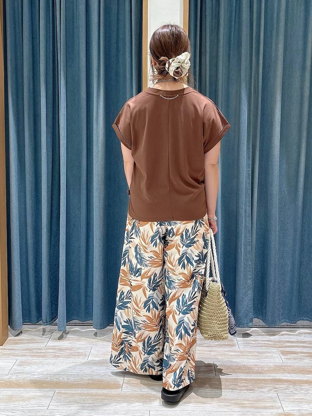 ベージュ系のトートバッグ、ブラウン系のその他パンツ、ブラック系のサンダルを着用したレディースの春コーディネートの3枚目の写真