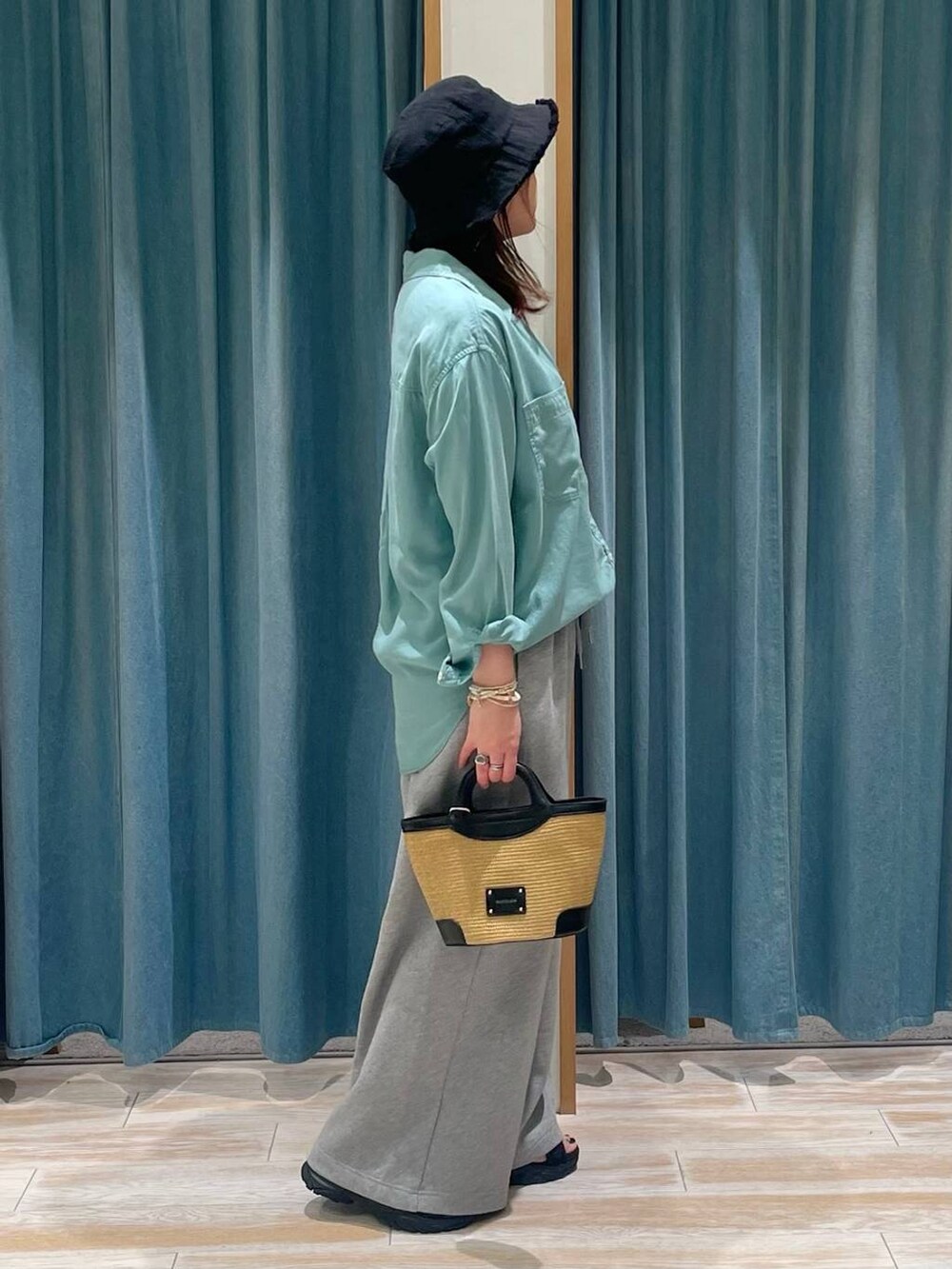 グリーン系のシャツ/ブラウス、ホワイト系のキャミソール、グレー系のスウェットパンツを着用したレディースの春コーディネートの2枚目の写真