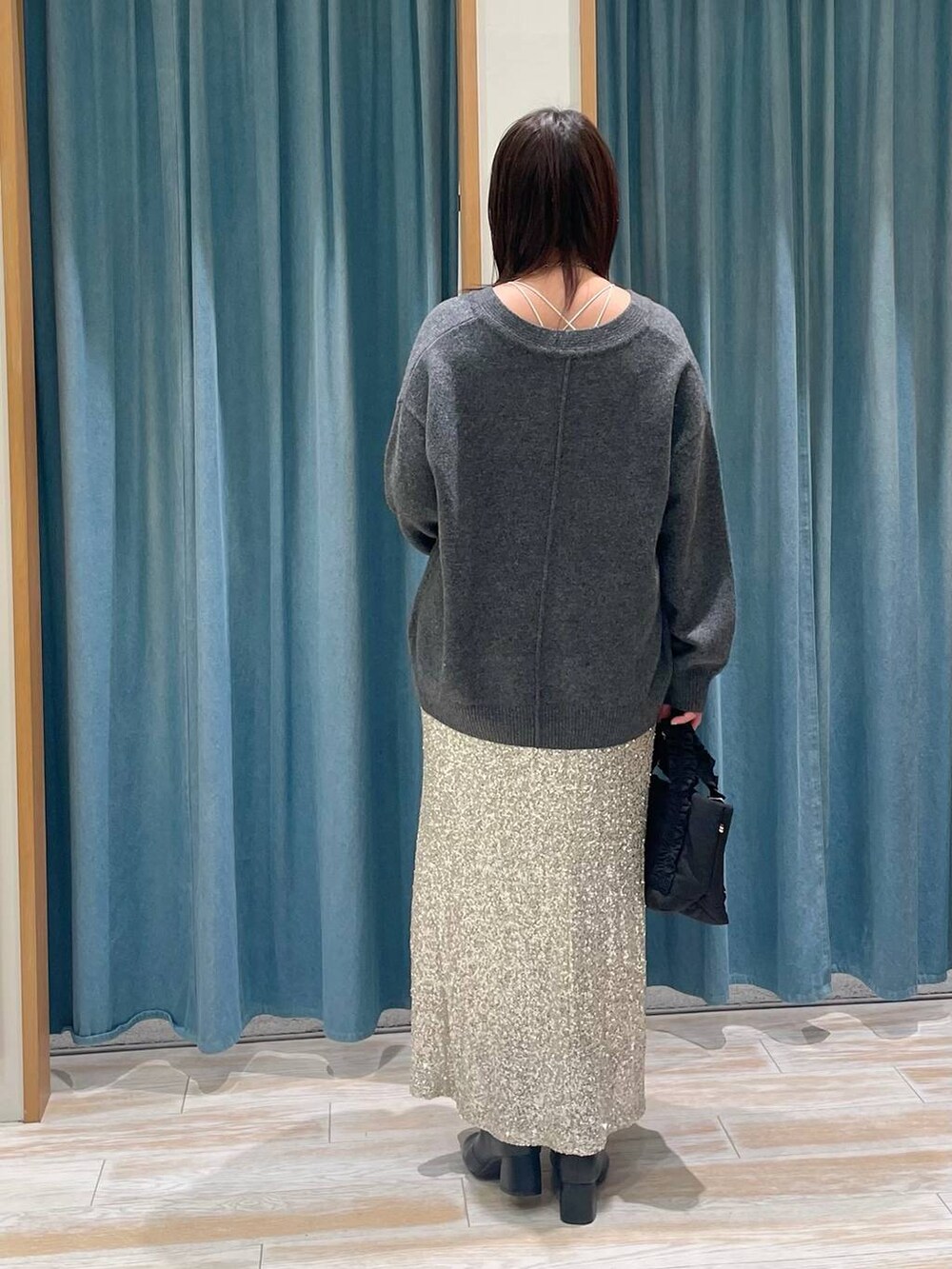 ブラック系のブーツ、グレー系のニット/セーター、ブラック系のトートバッグを着用したレディースの冬コーディネートの3枚目の写真