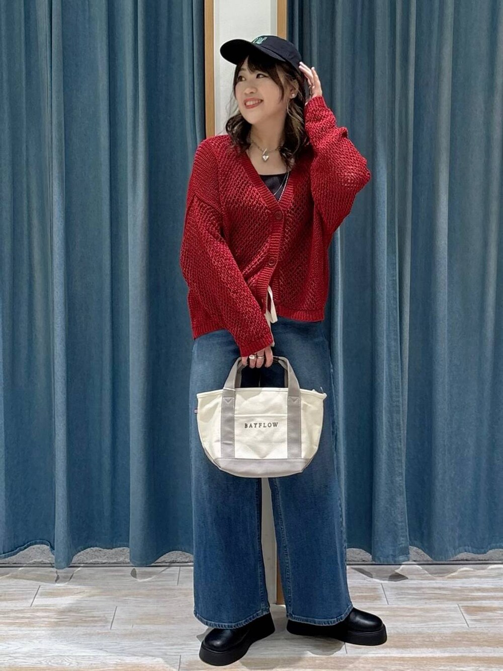 ブラック系のキャミソール、ブラック系のサンダル、ブルー系のデニムパンツを着用したレディースの秋コーディネートの4枚目の写真