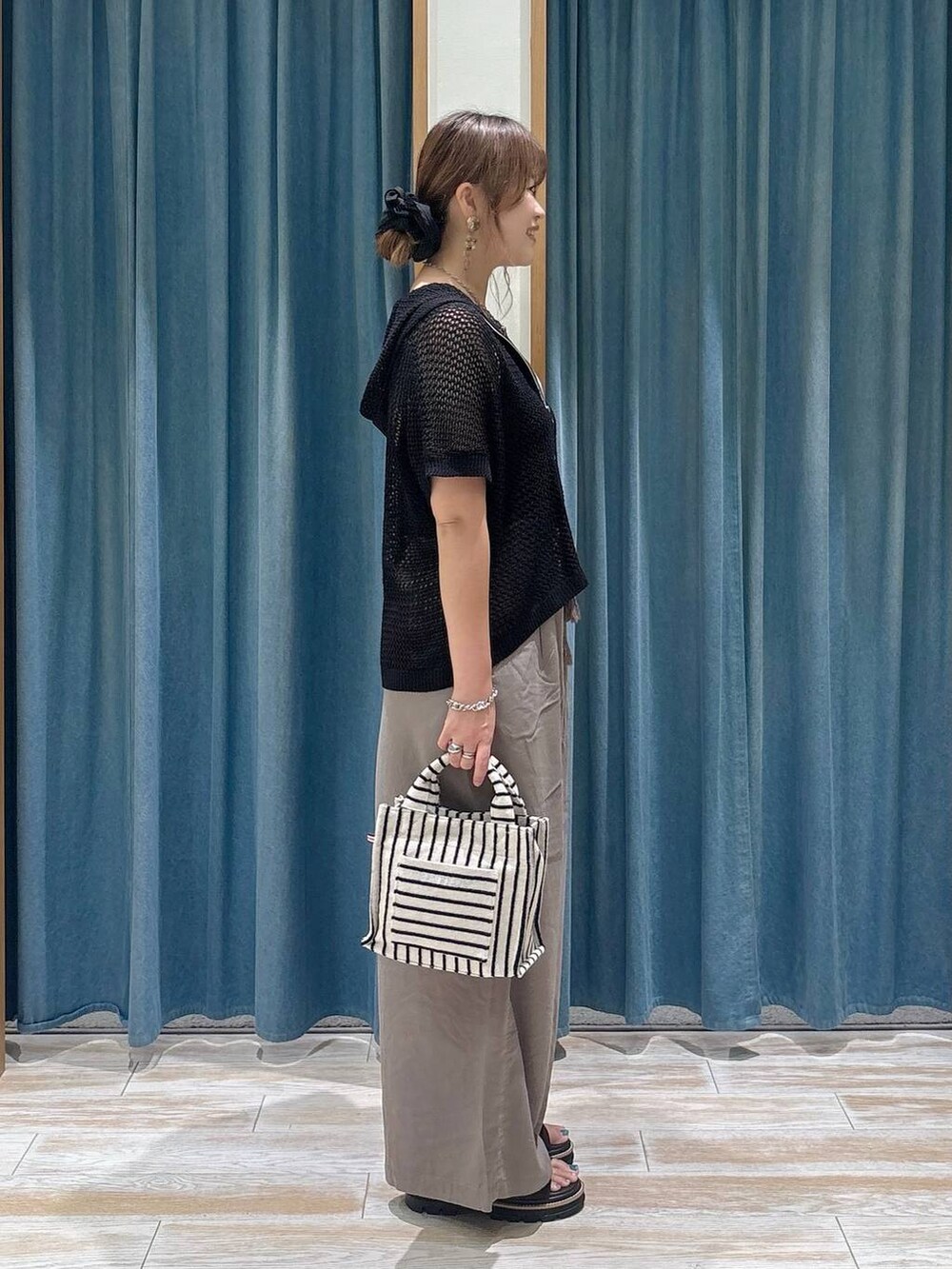 ブラウン系のその他パンツ、ブラウン系のサンダル、ベージュ系のトートバッグを着用したレディースの夏コーディネートの2枚目の写真