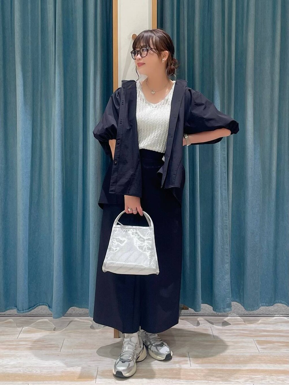 ホワイト系のキャミソール、シルバー系のハンドバッグ、ブラック系のシャツ/ブラウスを着用したレディースの春コーディネートの4枚目の写真
