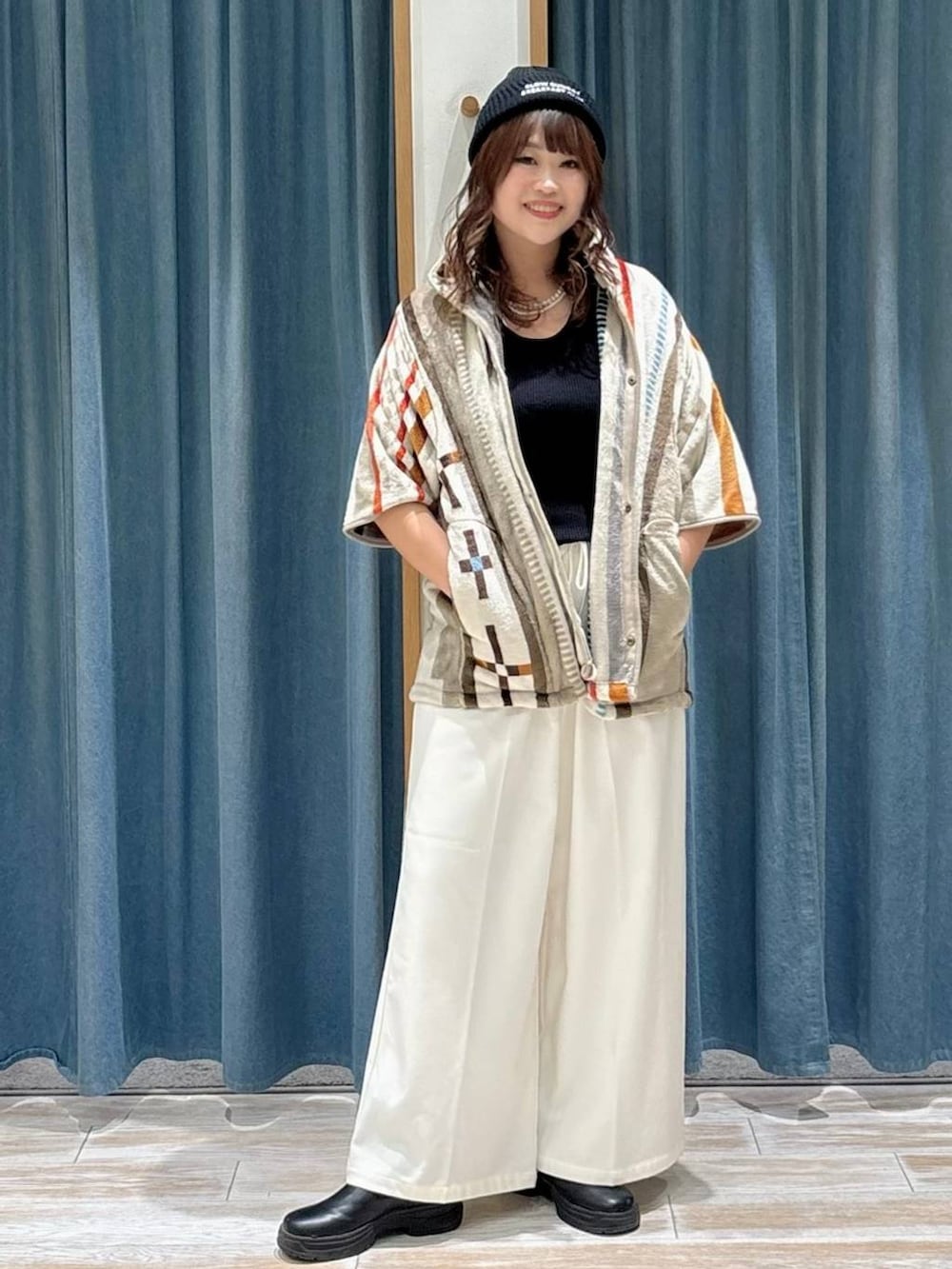 ベージュ系のその他パンツ、ブラック系のブーツ、グレー系のクッション/クッションカバーを着用したレディースの秋コーディネートの2枚目の写真