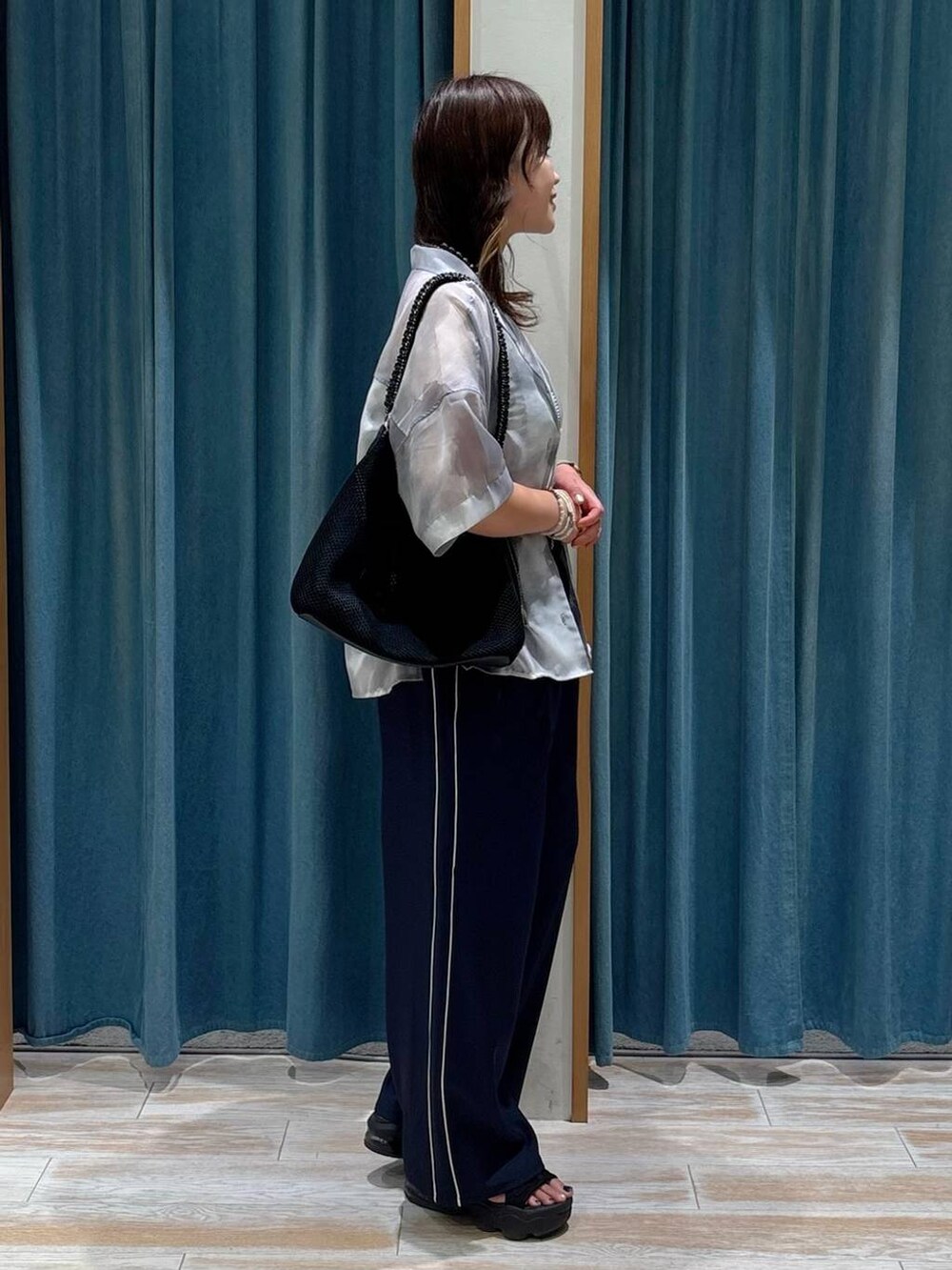 ホワイト系のキャミソール、ブラック系のハンドバッグ、グレー系のシャツ/ブラウスを着用したレディースの夏コーディネートの2枚目の写真