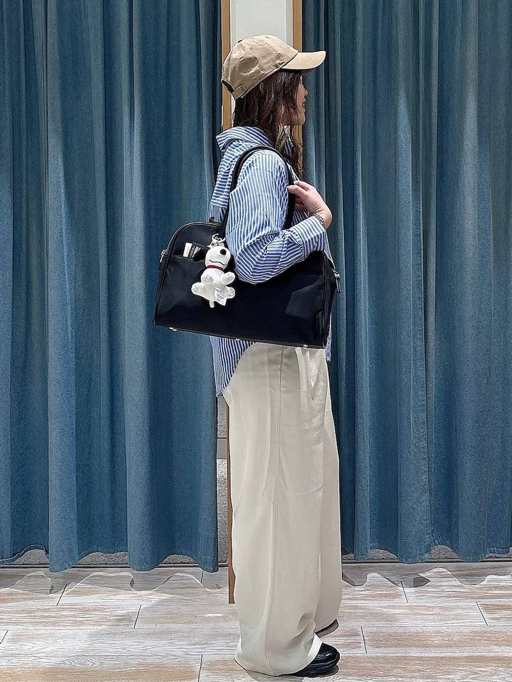 ブラック系のボストンバッグ、ベージュ系のその他パンツ、ブラック系のスニーカーを着用したレディースの冬コーディネートの2枚目の写真