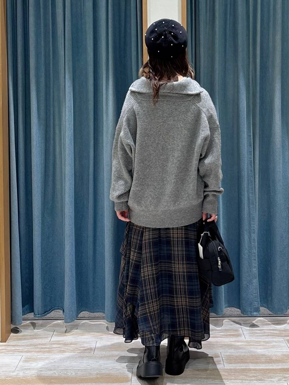 ブラック系のブーツ、ブラック系のボストンバッグ、グレー系のニット/セーターを着用したレディースの秋コーディネートの3枚目の写真