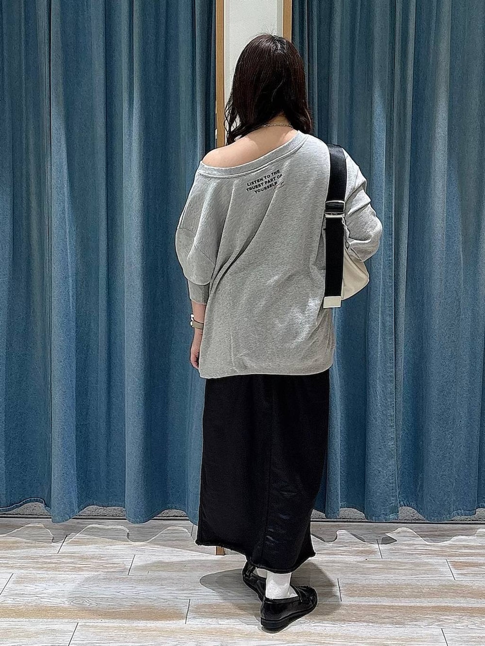 ブラック系のスカート、ブラック系のローファー、グレー系のスウェットを着用したレディースの冬コーディネートの3枚目の写真