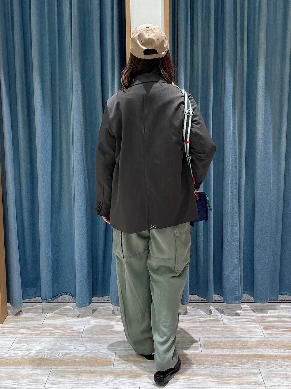 ブルー系のショルダーバッグ、ブラック系のパンプス、グレー系のテーラードジャケットを着用したレディースの春コーディネートの3枚目の写真