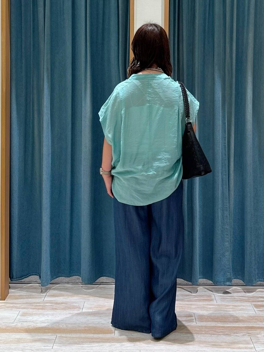 グリーン系のシャツ/ブラウス、シルバー系のサンダル、ブラック系のハンドバッグを着用したレディースの夏コーディネートの3枚目の写真