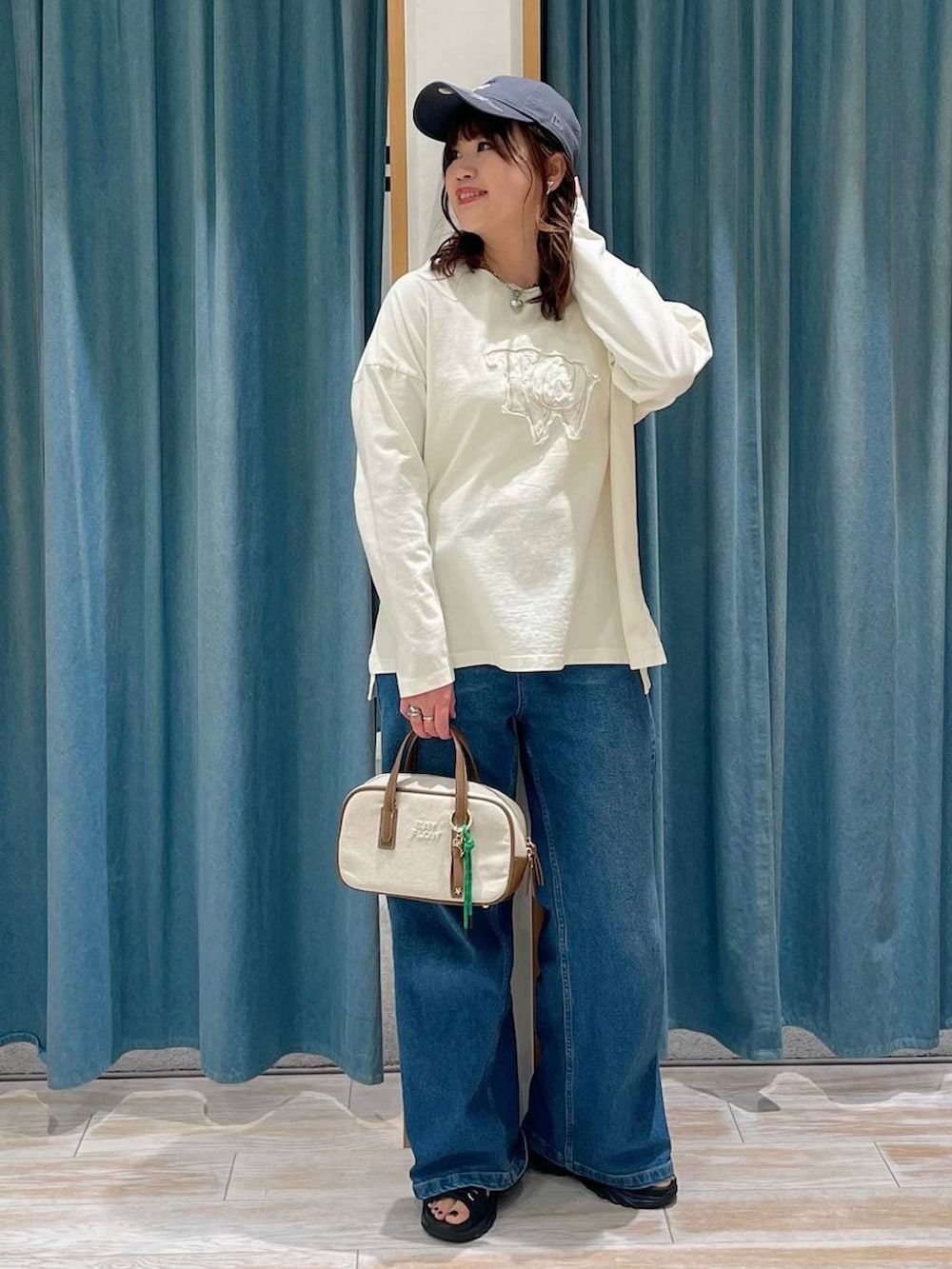 その他のショルダーバッグ、ブルー系のデニムパンツ、ブラック系のサンダルを着用したレディースの春コーディネートの4枚目の写真