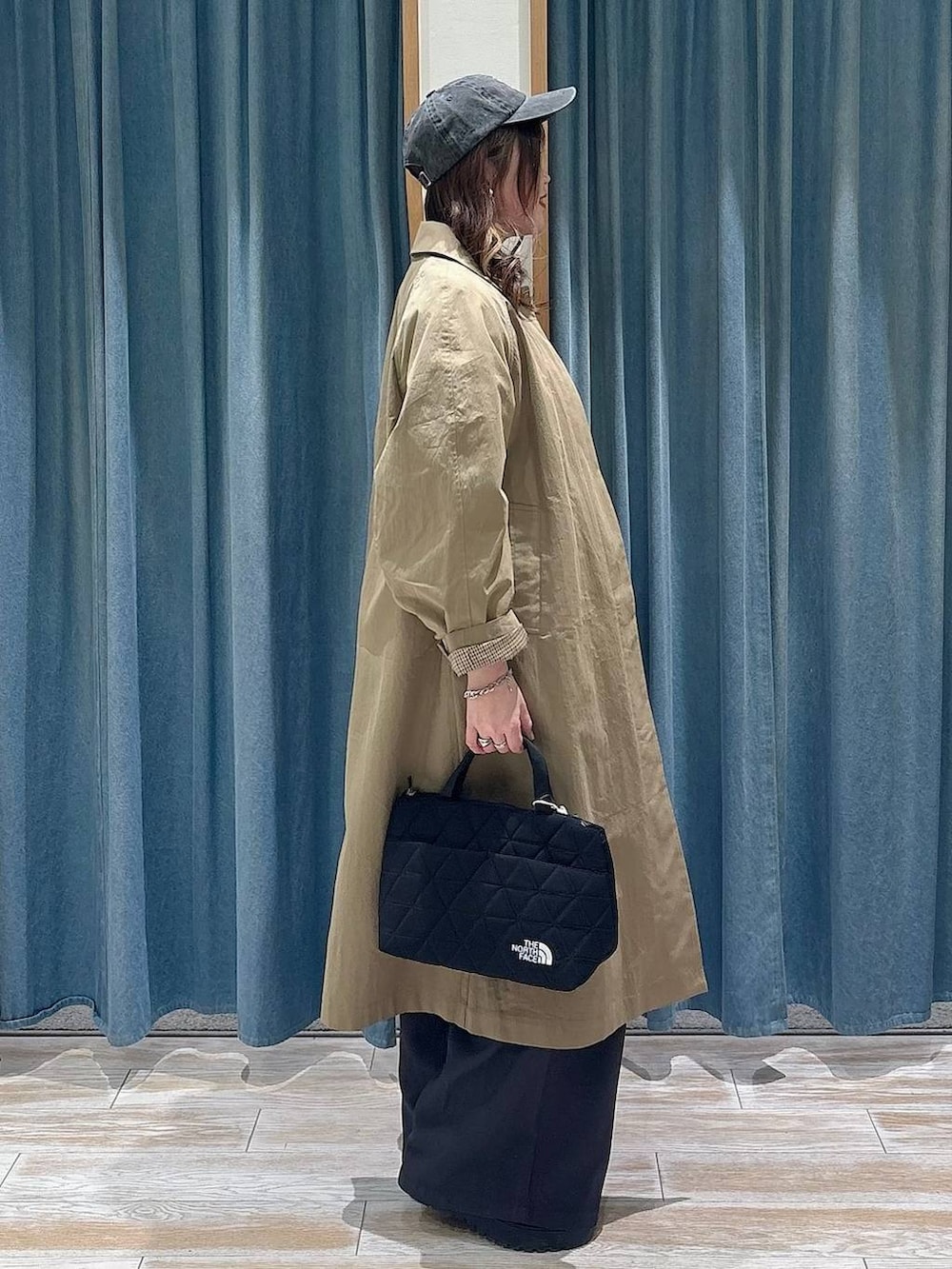 ブラック系のブーツ、ブラック系のトートバッグ、レッド系のスウェットを着用したレディースの冬コーディネートの2枚目の写真