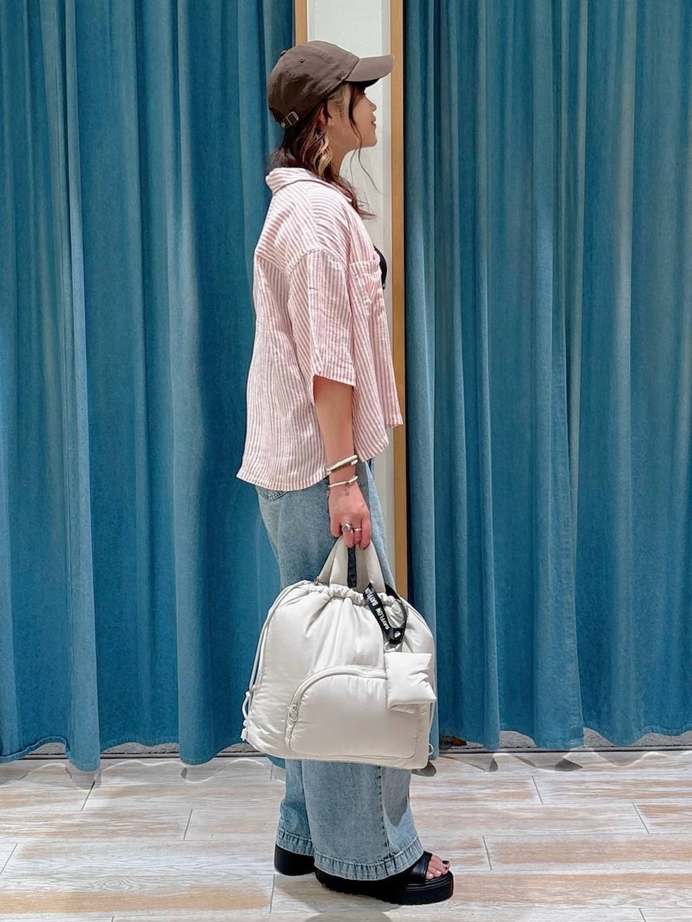 ブラック系のキャミソール、ブルー系のデニムパンツ、ブラック系のサンダルを着用したレディースの夏コーディネートの2枚目の写真