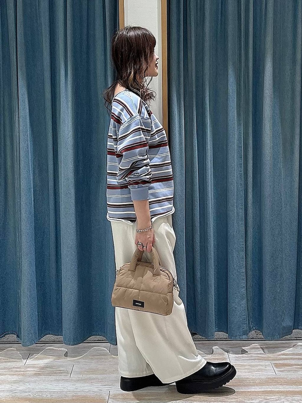 ベージュ系のその他パンツ、ブラック系のブーツ、ベージュ系のボストンバッグを着用したレディースの冬コーディネートの2枚目の写真