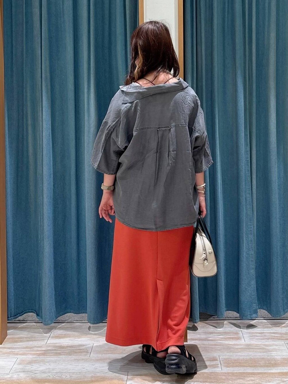 ブラック系のキャミソール、レッド系のスカート、グレー系のシャツ/ブラウスを着用したレディースの夏コーディネートの3枚目の写真