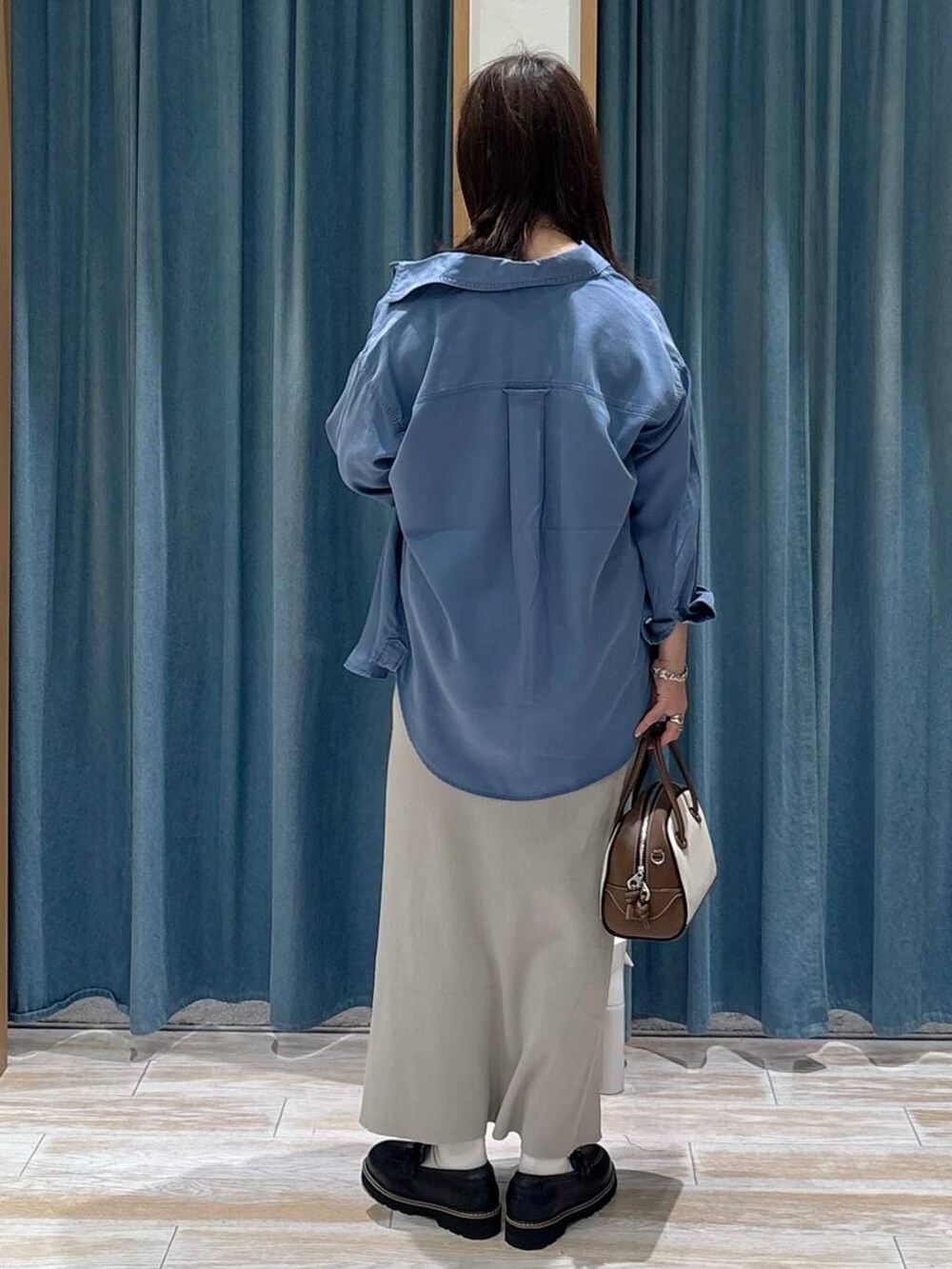 ブラック系のキャミソール、ブルー系のシャツ/ブラウス、ホワイト系のハンドバッグを着用したレディースの秋コーディネートの3枚目の写真