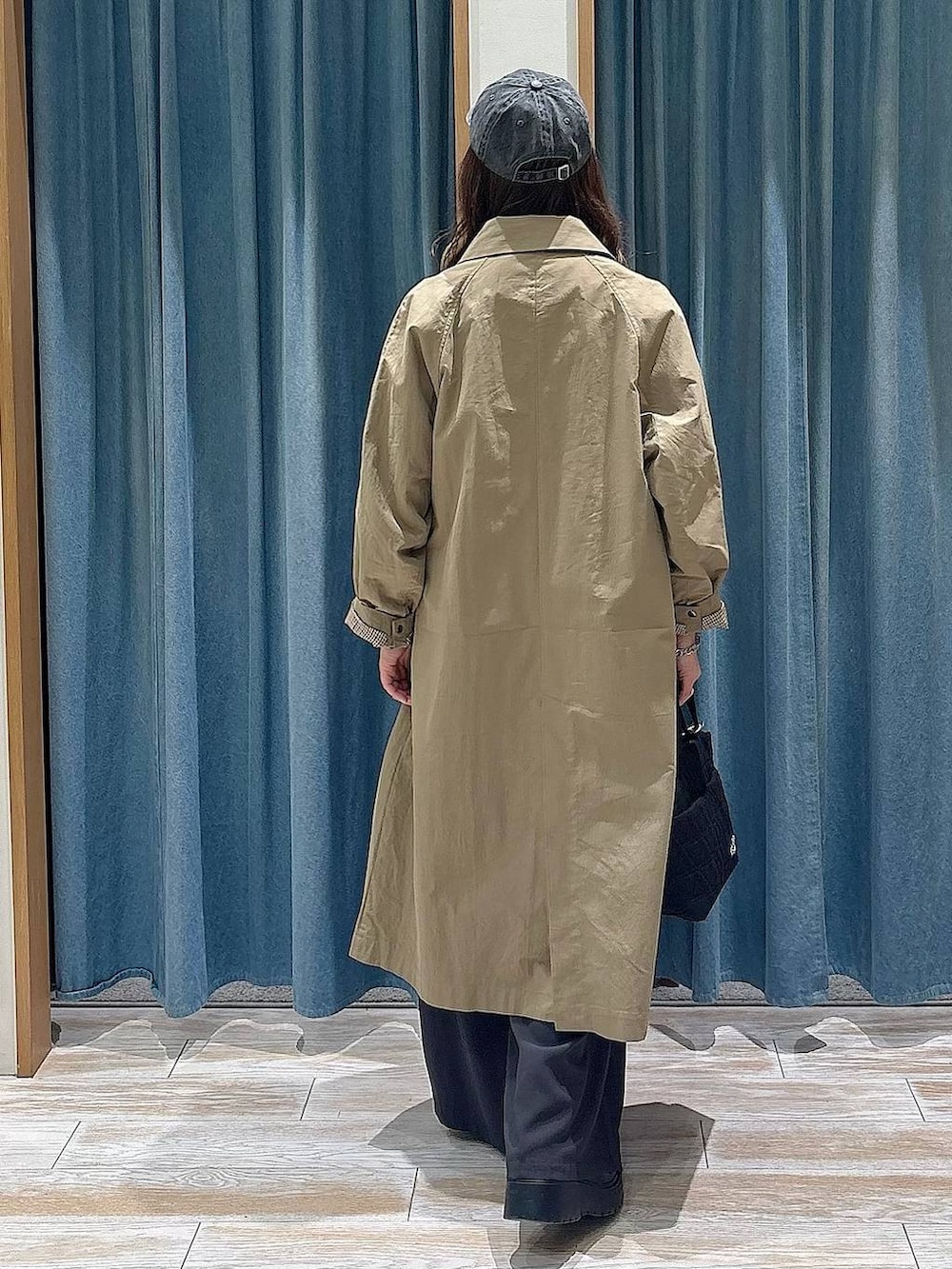 ブラック系のブーツ、ブラック系のトートバッグ、レッド系のスウェットを着用したレディースの冬コーディネートの3枚目の写真