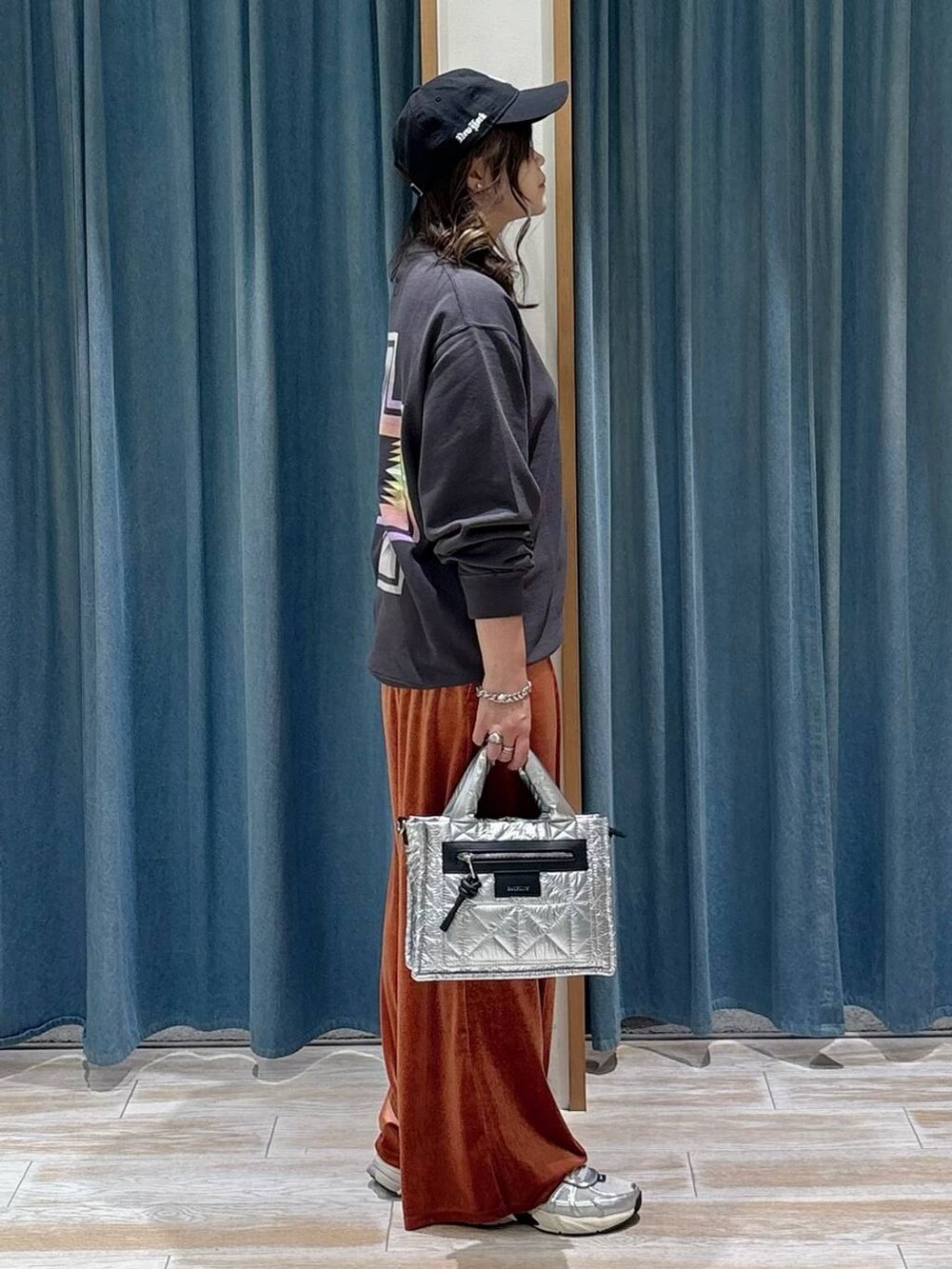 シルバー系のショルダーバッグ、ブラック系のスウェット、レッド系のその他パンツを着用したレディースの秋コーディネートの3枚目の写真