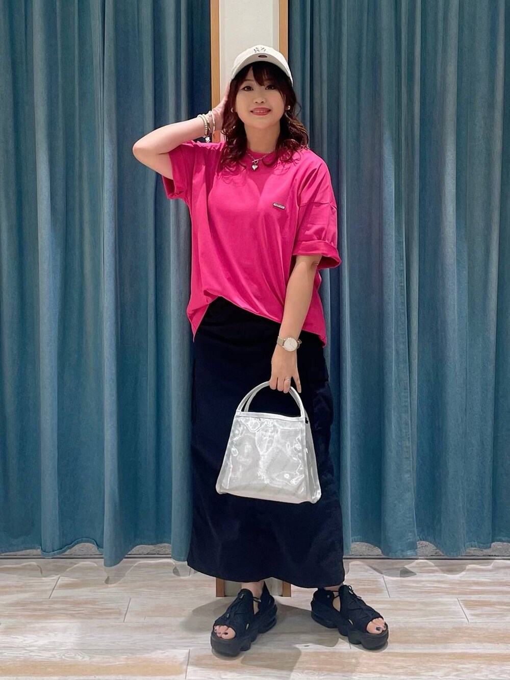 ブラック系のスカート、シルバー系のハンドバッグ、ピンク系のTシャツ/カットソーを着用したレディースの春コーディネートの4枚目の写真