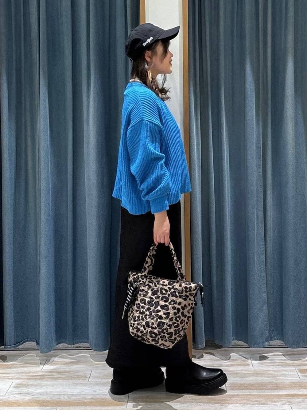 ブラック系のブーツ、ブラック系のスカート、その他のトートバッグを着用したレディースの冬コーディネートの2枚目の写真