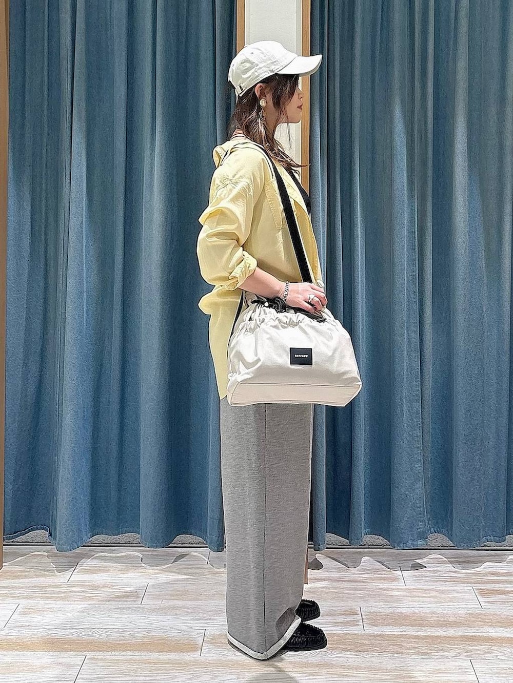 ホワイト系のトートバッグ、イエロー系のシャツ/ブラウス、ブラック系のローファーを着用したレディースの春コーディネートの2枚目の写真