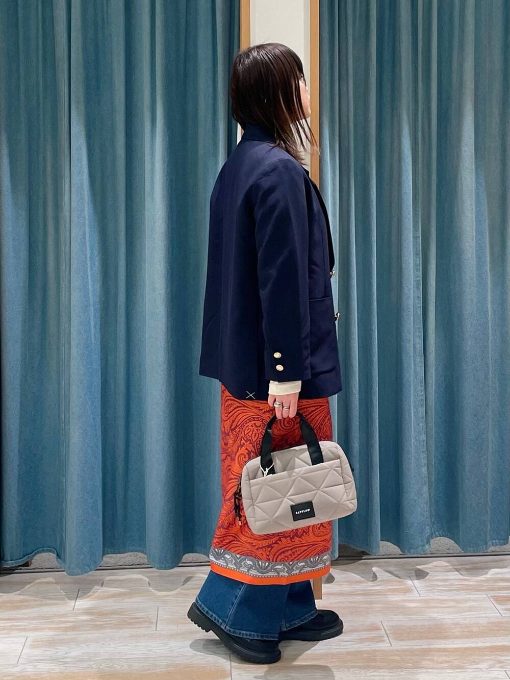 ブルー系のテーラードジャケット、ベージュ系のハンドバッグ、その他のローファーを着用したレディースの春コーディネートの2枚目の写真