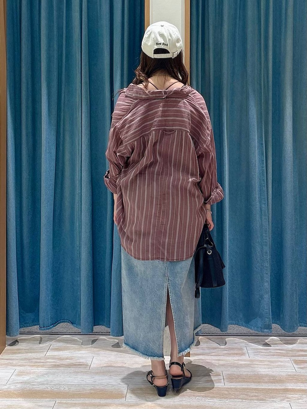 ブラウン系のシャツ/ブラウス、ブルー系のデニムスカート、ブラック系のショルダーバッグを着用したレディースの春コーディネートの3枚目の写真