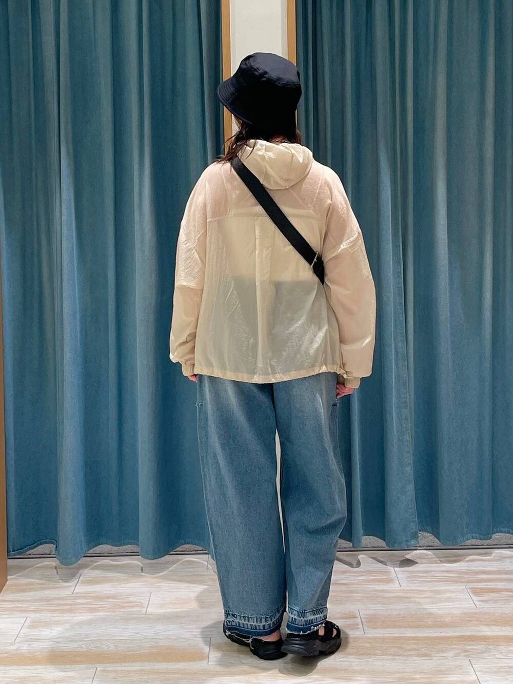 ホワイト系のキャミソール、ブルー系のデニムパンツ、ブラック系のサンダルを着用したレディースの春コーディネートの3枚目の写真