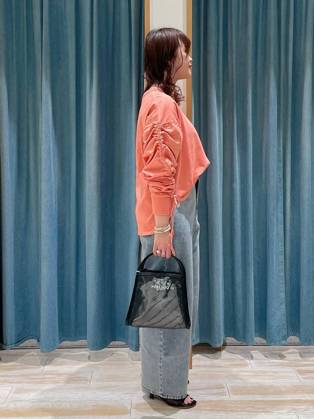 ブルー系のデニムパンツ、ブラック系のサンダル、ピンク系のTシャツ/カットソーを着用したレディースの春コーディネートの2枚目の写真