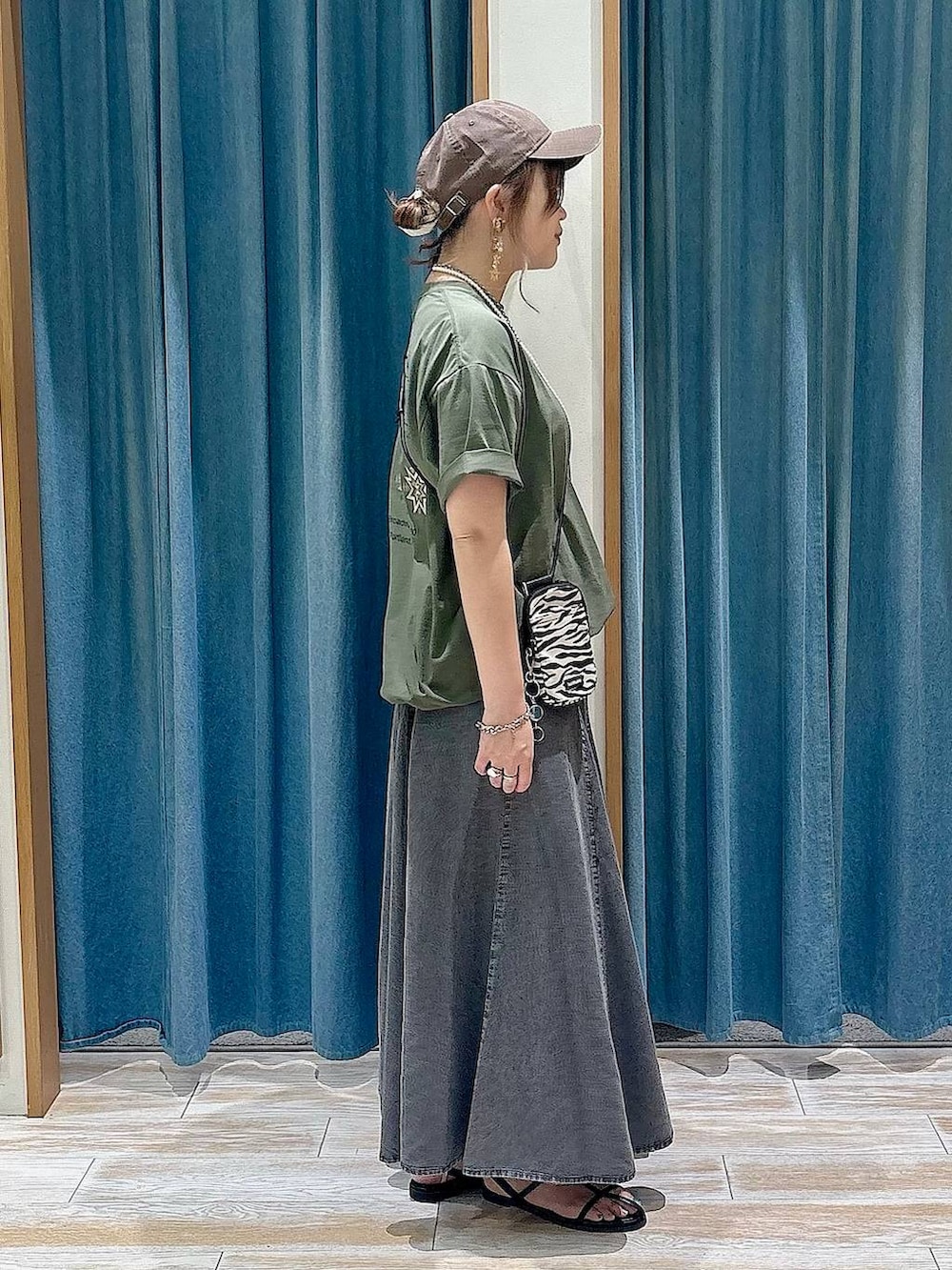 ベージュ系のショルダーバッグ、グリーン系のTシャツ/カットソー、ブラック系のスカートを着用したレディースの春コーディネートの3枚目の写真