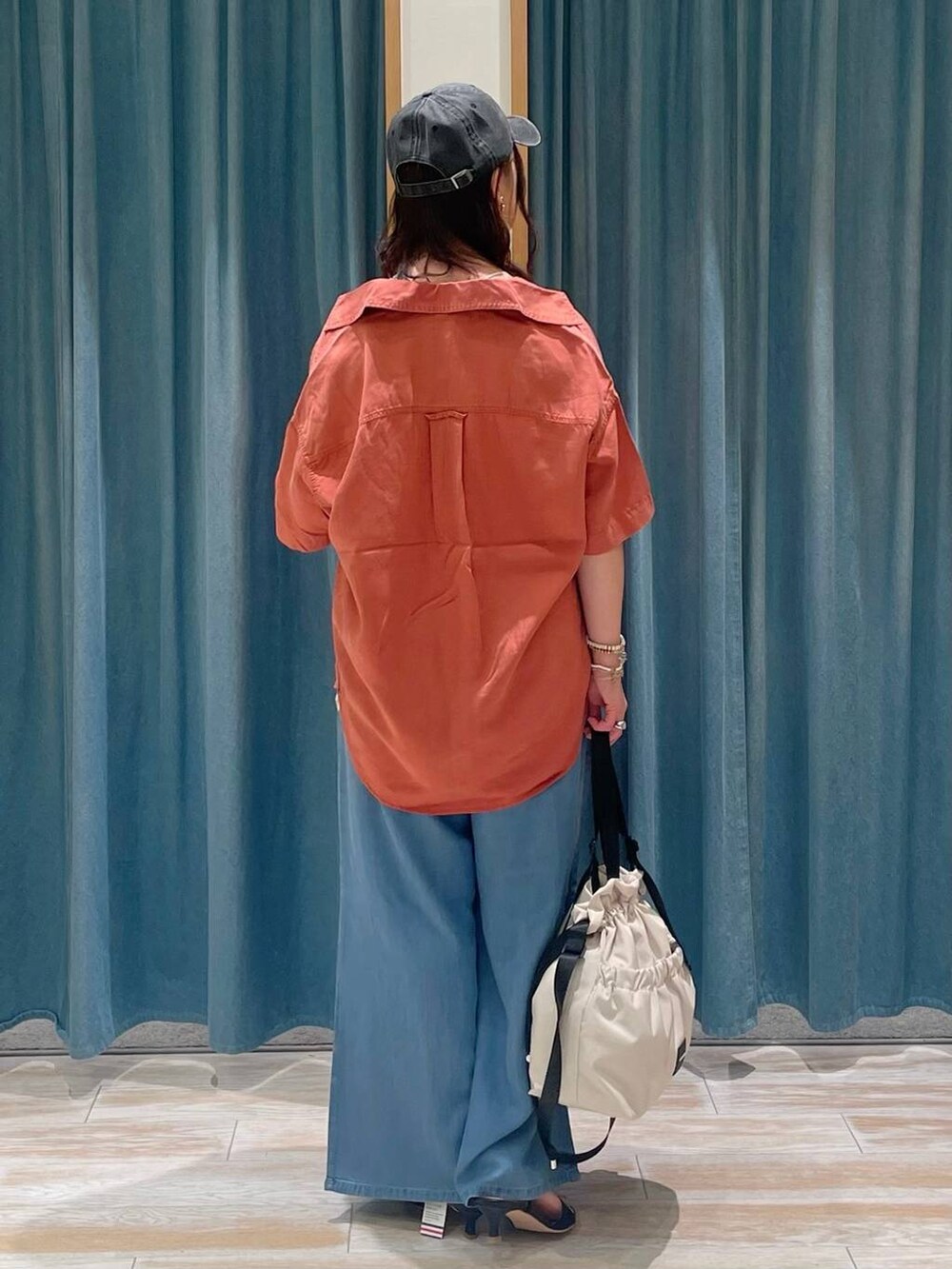 ホワイト系のキャミソール、ホワイト系のトートバッグ、オレンジ系のシャツ/ブラウスを着用したレディースの春コーディネートの3枚目の写真