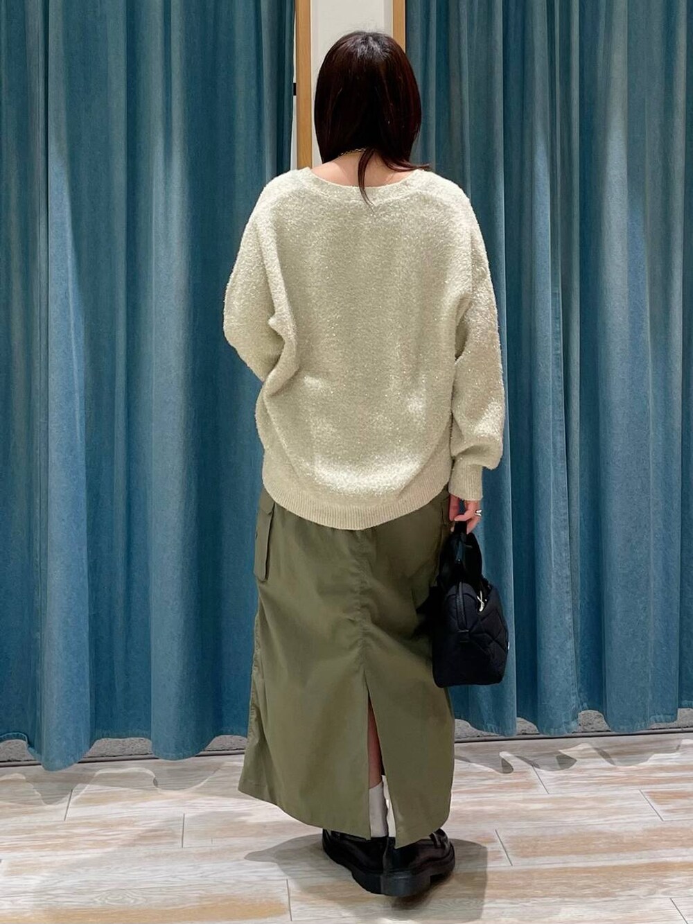 ブラック系のハンドバッグ、その他のローファー、ホワイト系のカーディガン/ボレロを着用したレディースの冬コーディネートの3枚目の写真