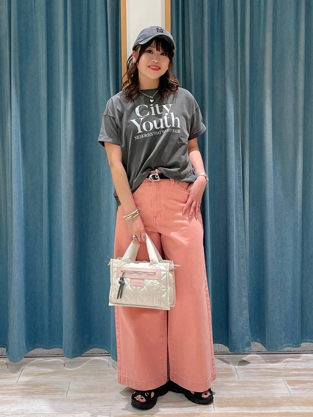 グレー系のTシャツ/カットソー、ホワイト系のショルダーバッグ、ピンク系のデニムパンツを着用したレディースの春コーディネートの4枚目の写真