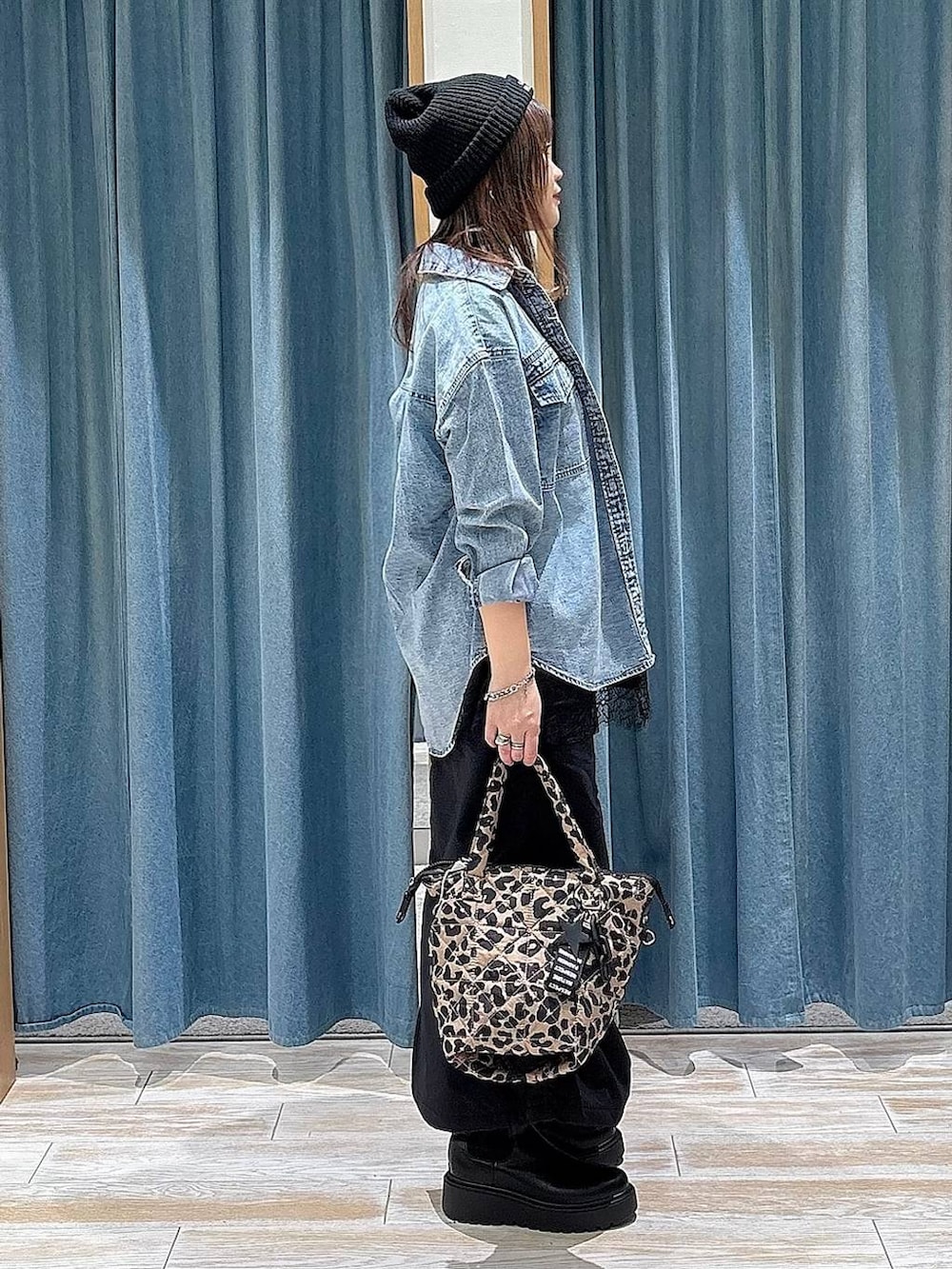 ブラック系のスカート、ブラック系のブーツ、ブルー系のシャツ/ブラウスを着用したレディースの冬コーディネートの2枚目の写真