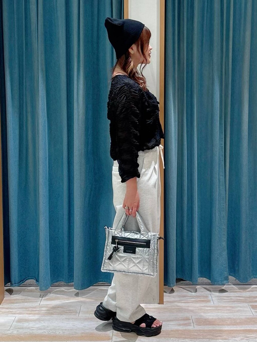 シルバー系のショルダーバッグ、ベージュ系のその他パンツ、ブラック系のカーディガン/ボレロを着用したレディースの夏コーディネートの2枚目の写真