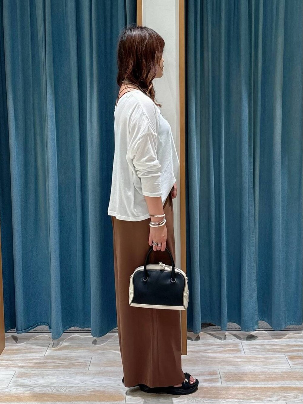 ブラック系のキャミソール、ブラック系のサンダル、ブラック系のハンドバッグを着用したレディースの夏コーディネートの2枚目の写真