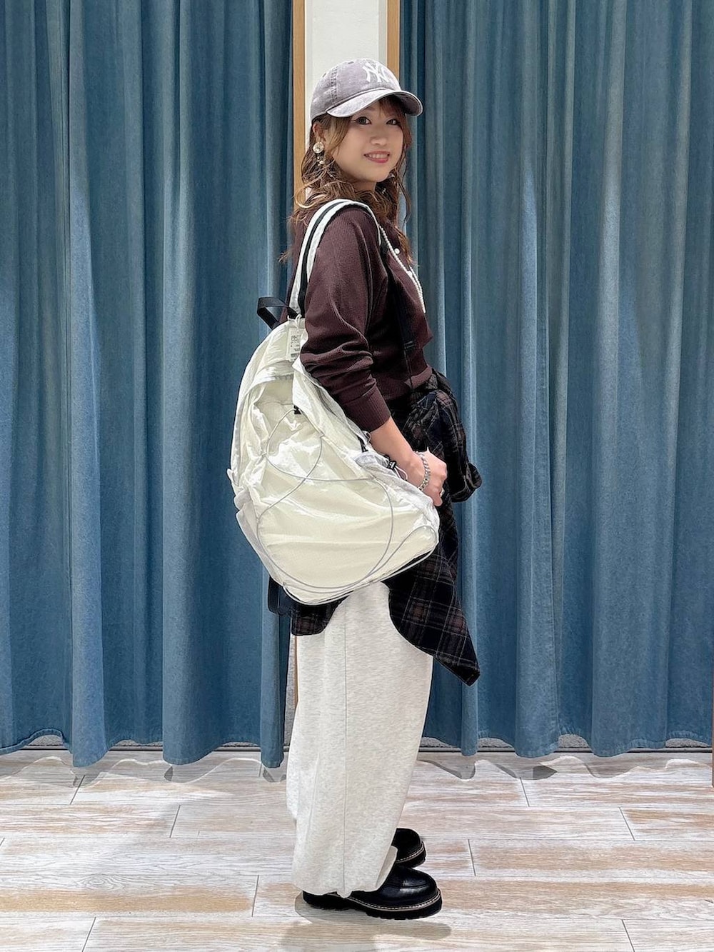 ベージュ系のスウェットパンツ、ホワイト系のバックパック/リュック、ブラウン系のTシャツ/カットソーを着用したレディースの秋コーディネートの2枚目の写真