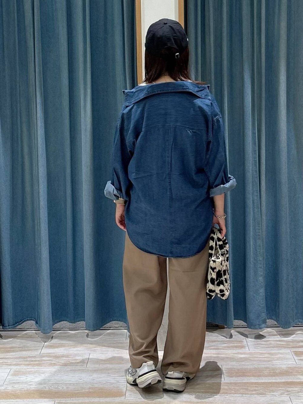 ブルー系のシャツ/ブラウス、ホワイト系のベスト、ベージュ系のトートバッグを着用したレディースの秋コーディネートの3枚目の写真