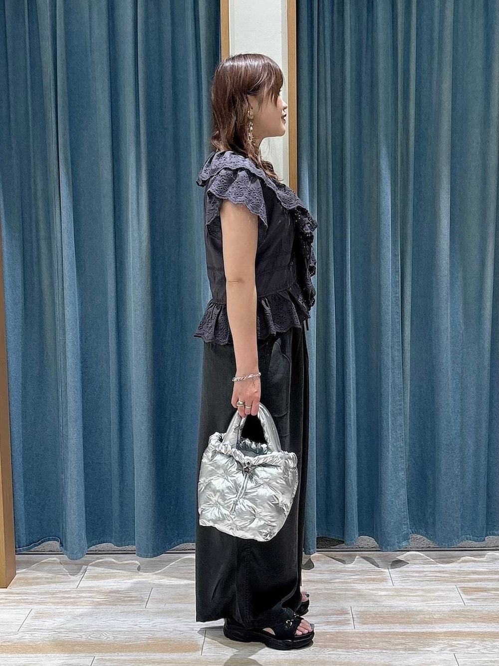 グレー系のその他パンツ、シルバー系のショルダーバッグ、ブラック系のサンダルを着用したレディースの春コーディネートの2枚目の写真