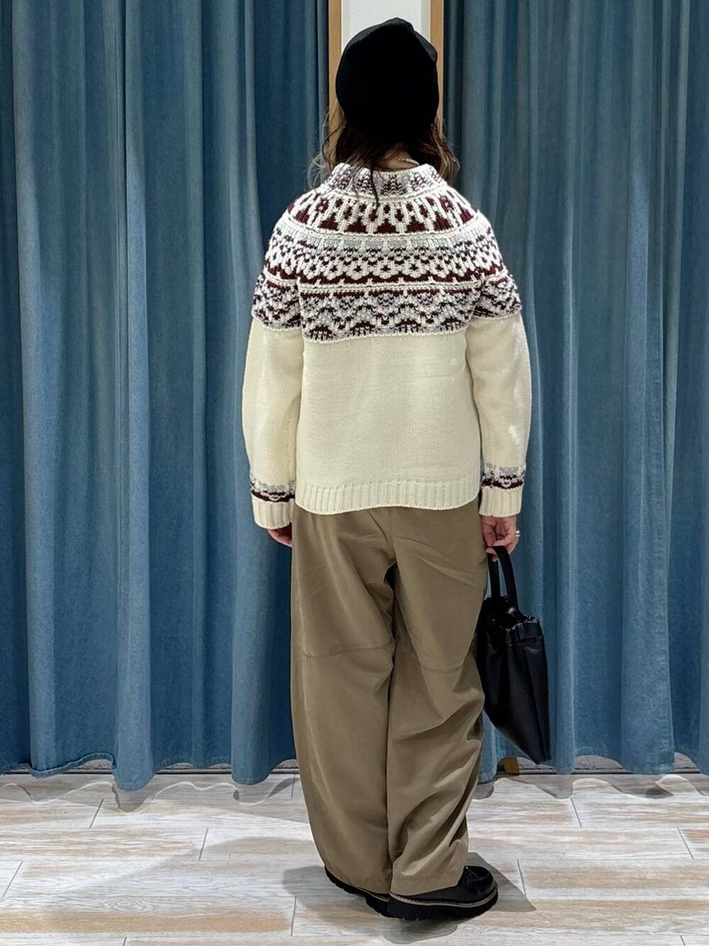 ブラック系のローファー、ブラック系のハンドバッグ、ホワイト系のニット/セーターを着用したレディースの秋コーディネートの3枚目の写真