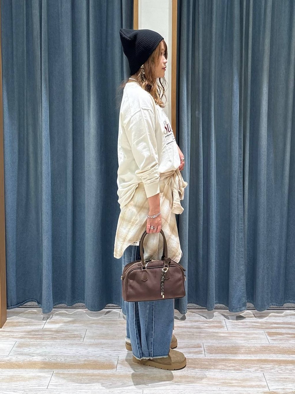 ベージュ系のその他シューズ、ブルー系のデニムパンツ、ブラウン系のハンドバッグを着用したレディースの秋コーディネートの2枚目の写真